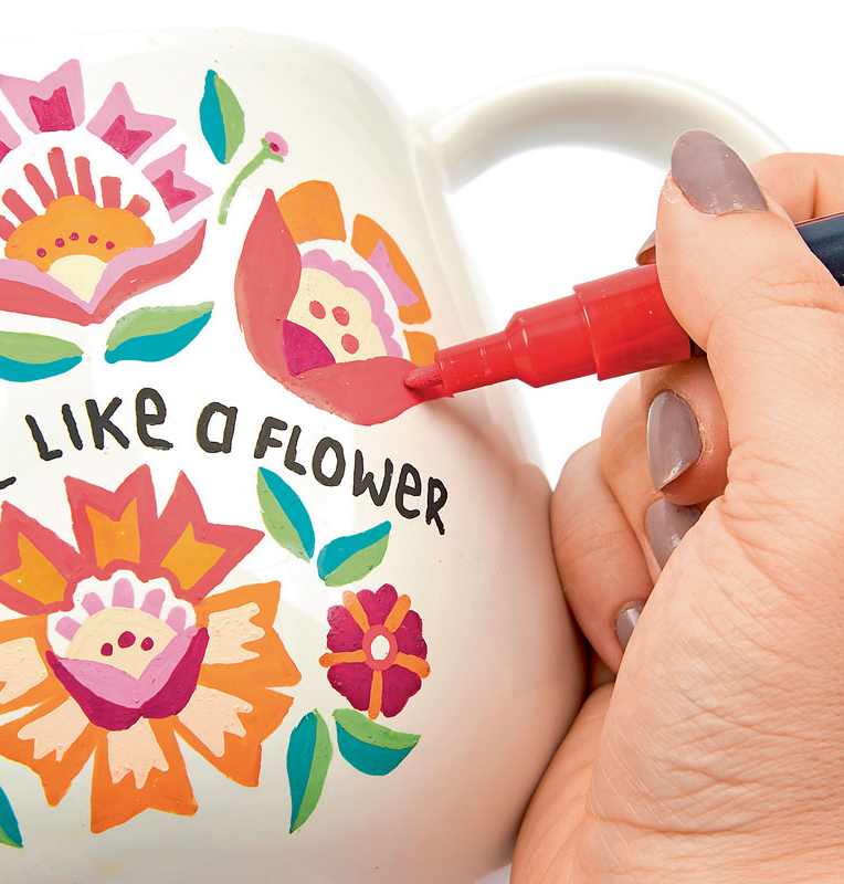 Bunte Blumenmuster auf Tasse, handgemalt mit leuchtenden Farben. DIY, kreativ, einzigartig gestaltet.