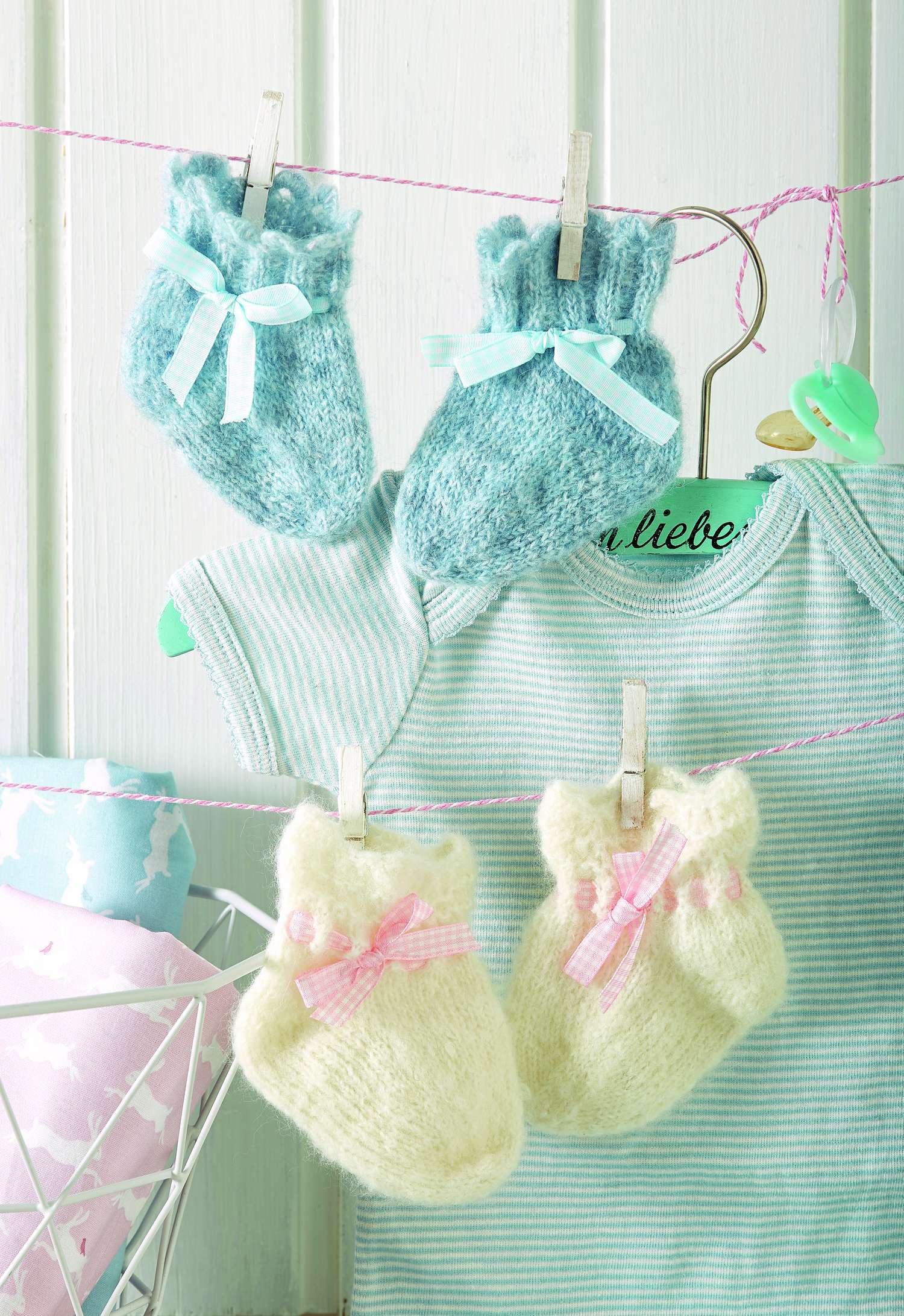 Handgestrickte, flauschige Babysocken in Blau und Creme, verziert mit Schleifen, strahlt DIY-Charme aus.