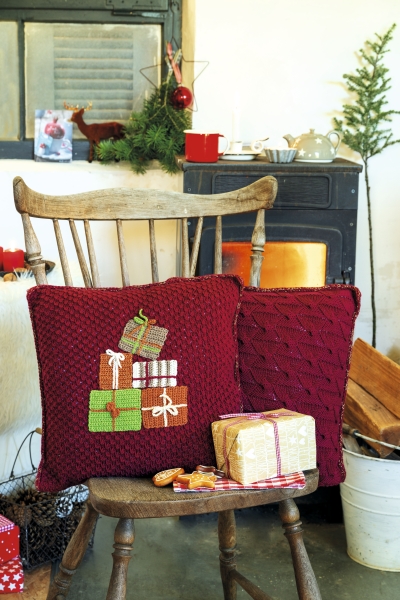 Handgemachte rote Strickkissen mit Geschenk-Muster; winterlich, kuschelig, festlich.