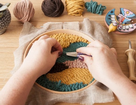 Modische, selbstgemachte Stickerei in bunten Erdtönen; kreative Handarbeit mit Texturmuster.