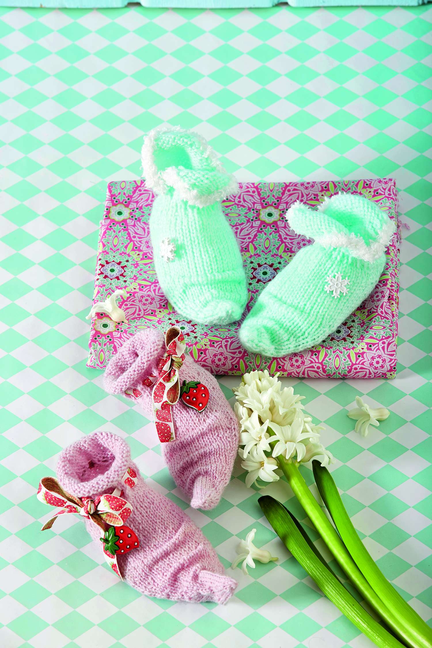 Zarte, pastellfarbene Babyschuhe, handgemacht. Minzgrün mit Schneeflocken, rosa mit Erdbeer-Muster.