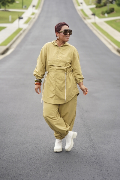 Olivgrüner Zweiteiler, lockerer Schnitt, Taillenzug, weiße Sneaker, modisch, urbaner Stil.