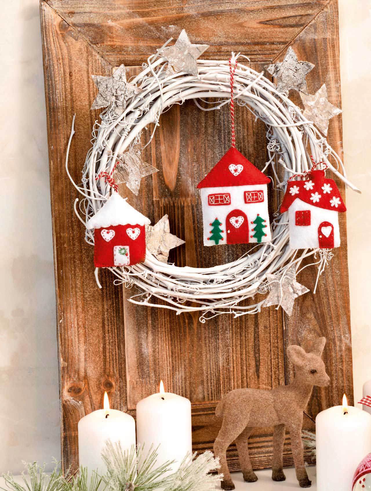 Weiße, rote Filzhäuser & Sterne verzieren Kranz. Handgemacht, rustikal, weihnachtliches Flair.