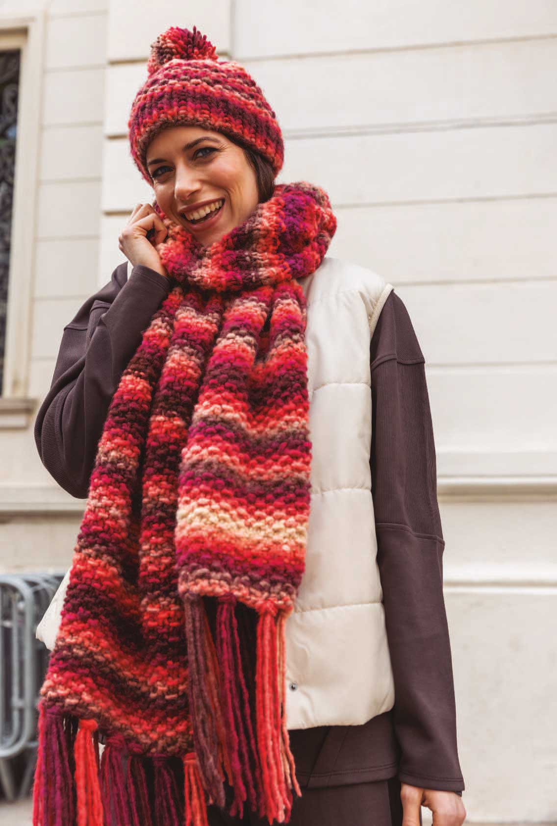 Bunte, gestrickte Mütze und Schal in warmen Erdtönen. Strickmuster, modisch handgemacht, DIY-Stil.