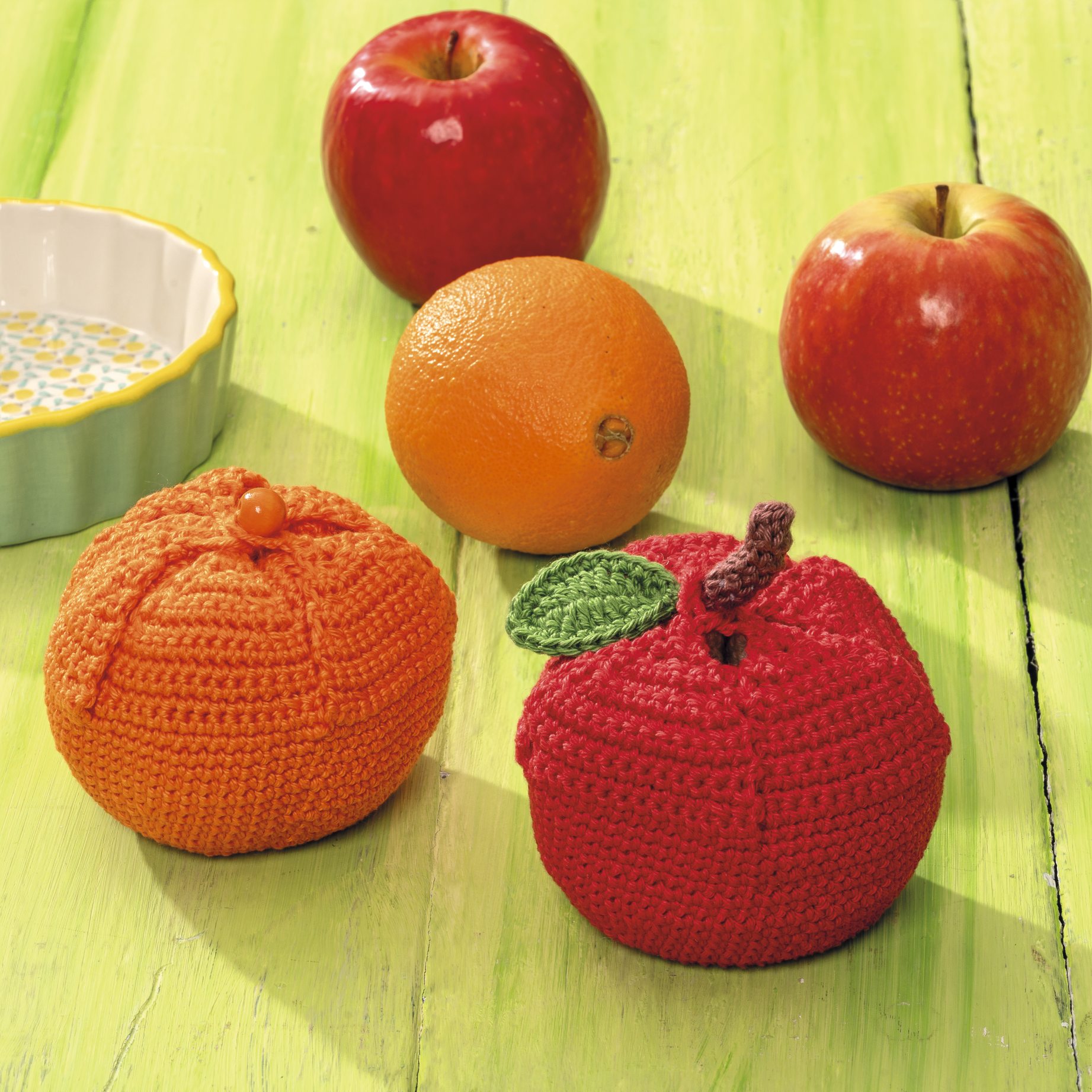 Handgemachte, gehäkelte Frucht-Dekoration. Rot und orange, detailreich, modisch, DIY-Chic.