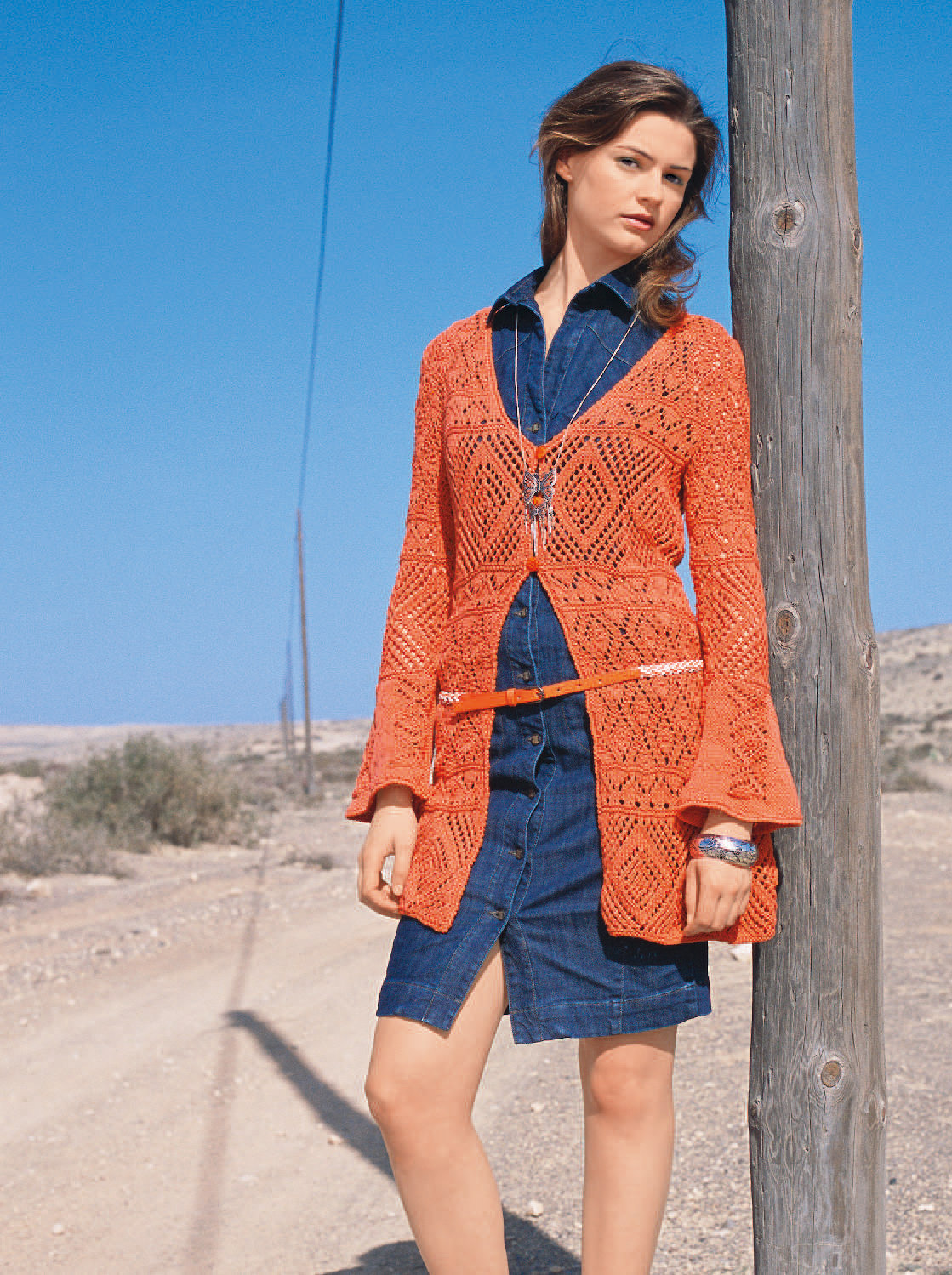 Modischer Look: Orangefarbener, selbstgemachter Häkel-Cardigan über schlichtem Jeanskleid. Handarbeit trifft Denim.