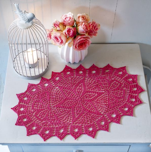 Rosa, handgemachtes Häkeldeckchen mit komplexem Muster und gezacktem Rand. Elegante Handarbeit.