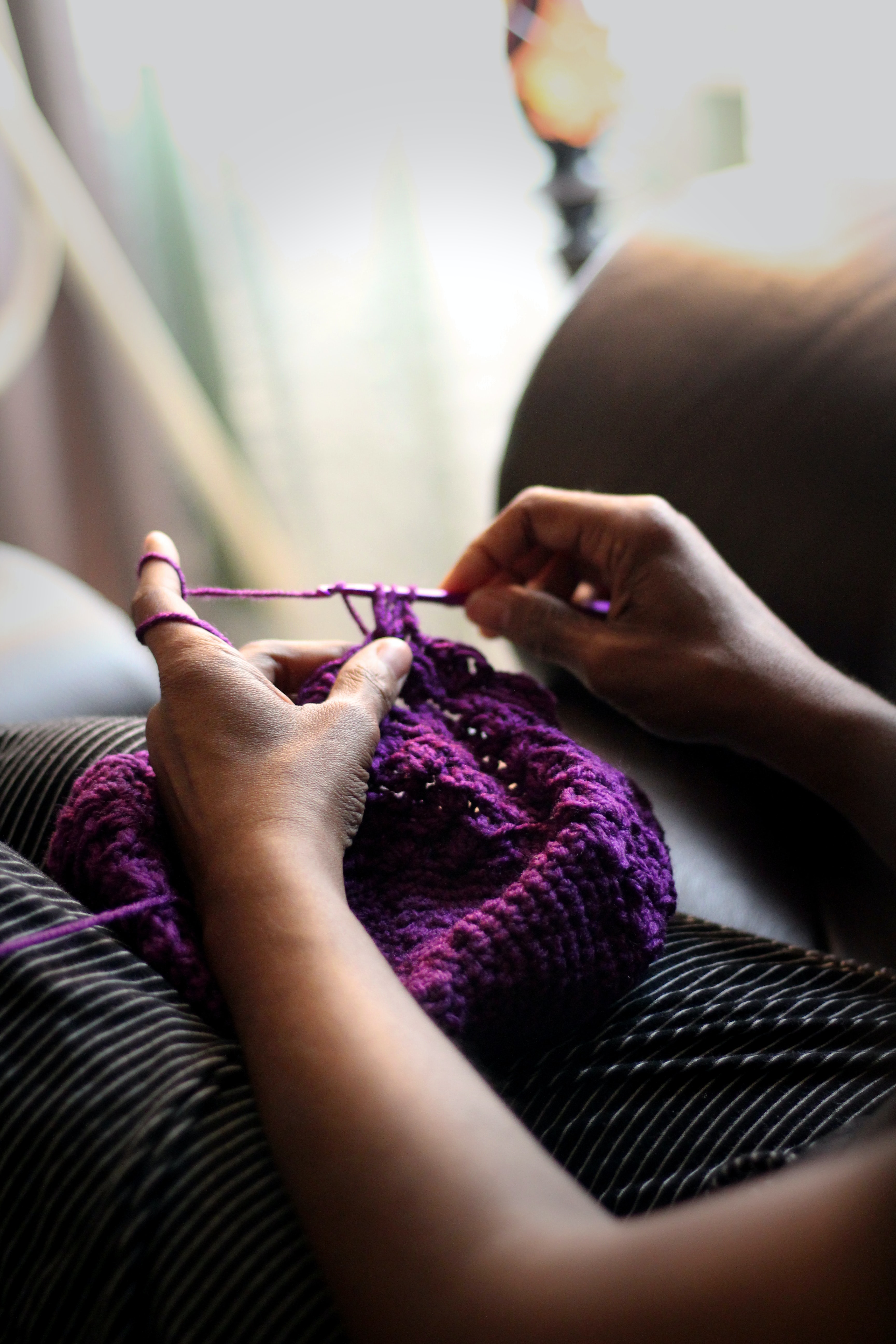 Handarbeit in lila Wolle, modisch und selbstgemacht; gestricktes DIY-Kleidungsstück mit liebevollen Details.