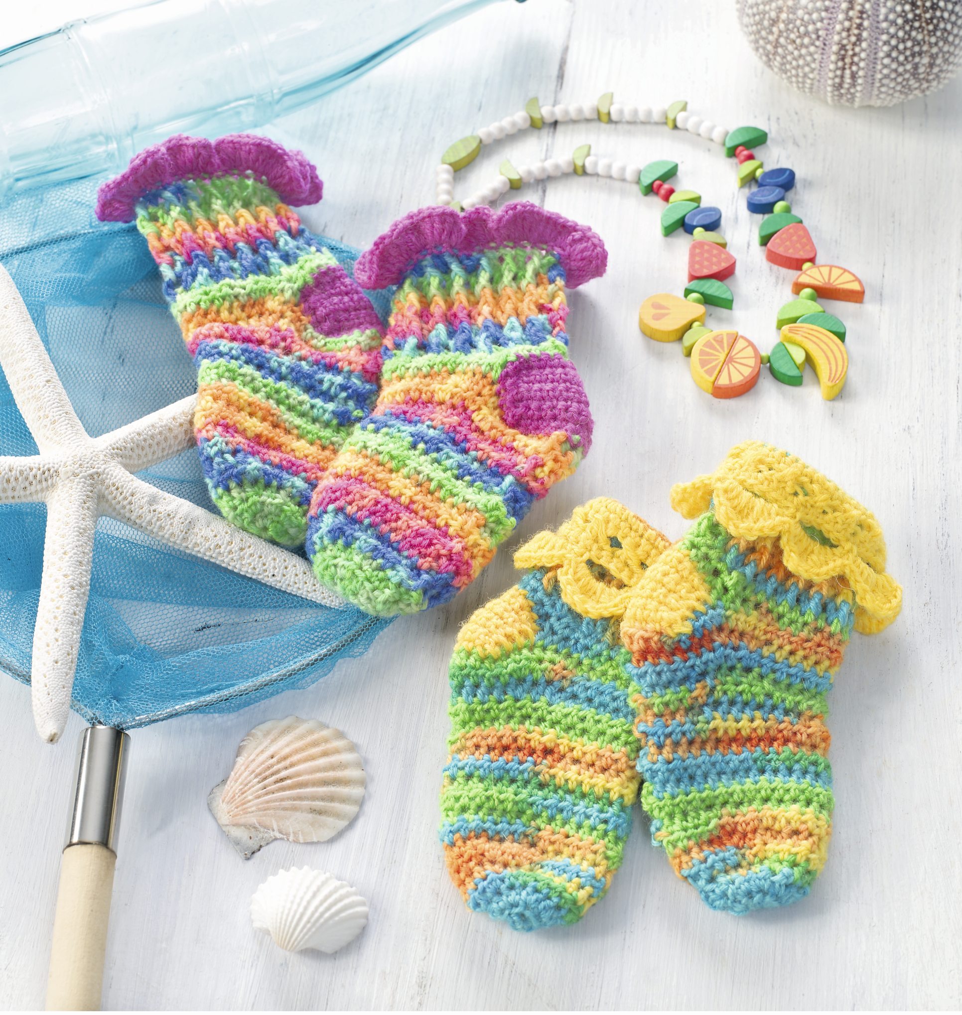 Handgemachte Socken mit regenbogenfarbigen Streifen, verspielten Rüschen, leuchtend und DIY.