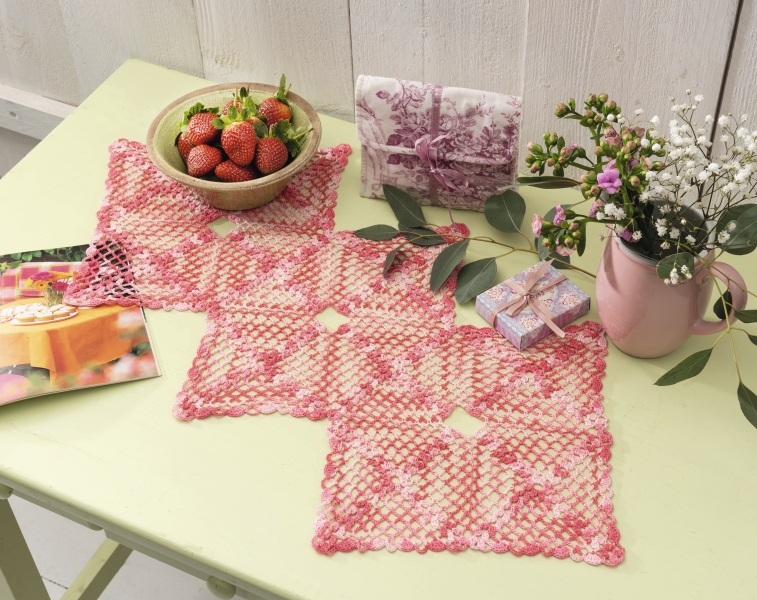 Häkelarbeit in rosa-weiß, geometrische Muster, handgemacht mit filigranen Details.