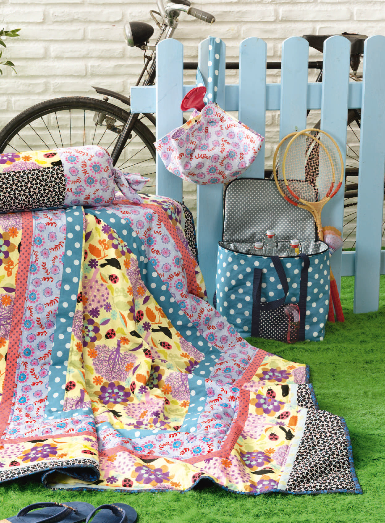 Bunte Patchworkdecke in leuchtenden Farben, floralen Mustern, DIY-Stil, kombiniert mit Punkten und Schachbrett.