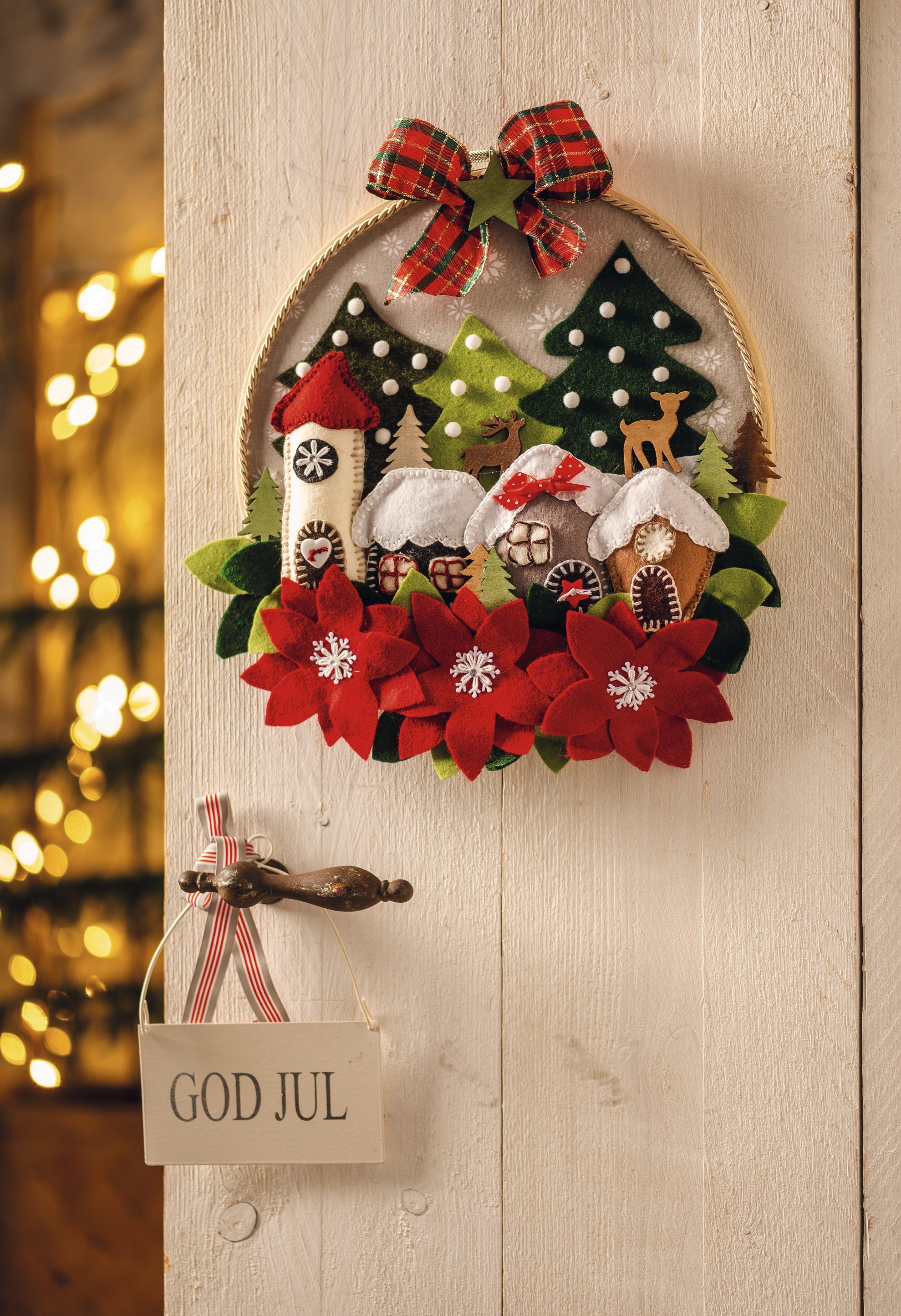 Handgemachter Kranz mit roten Blüten, grünen Tannenbäumen, gestreifter Schleife; winterliches DIY-Muster.