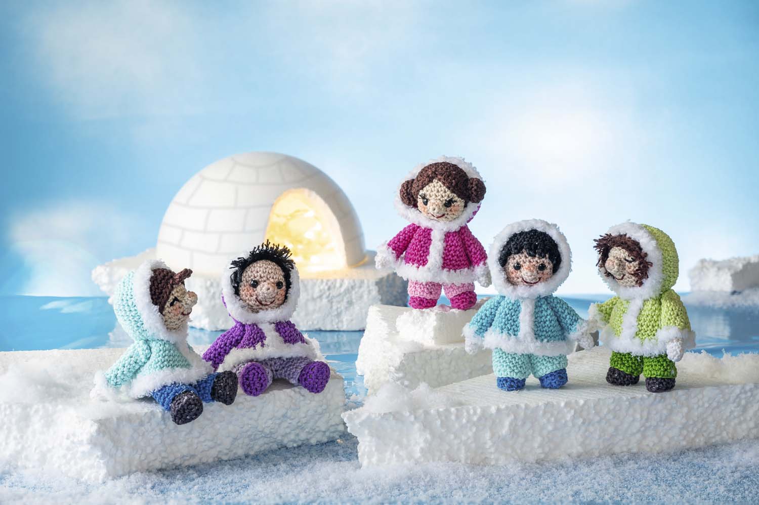 Bunte gestrickte Puppen, farbenfrohe Anzüge, handgemacht, kuschelige Details, DIY-Charme.