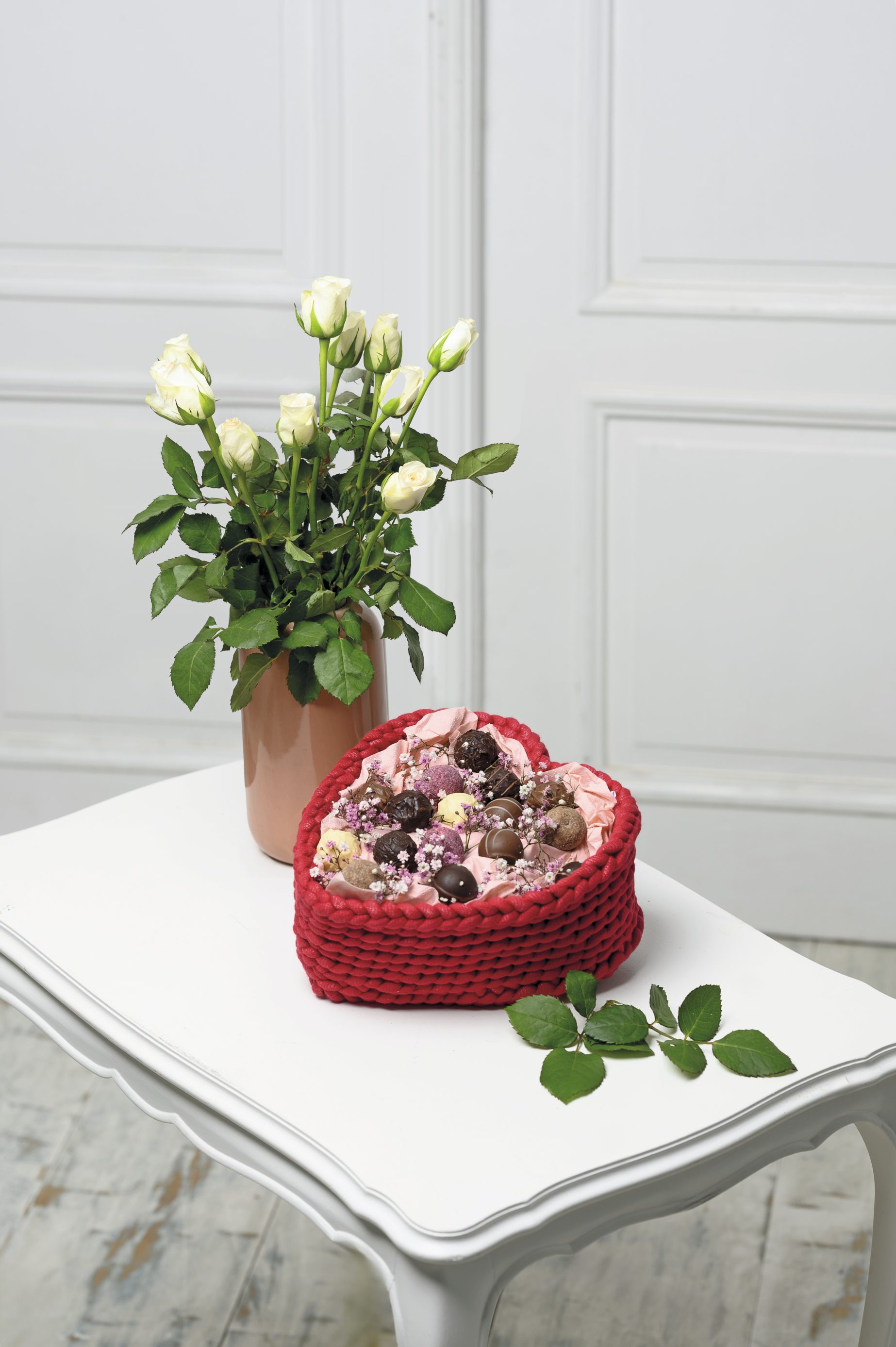 DIY rotes Herzkorb mit gestricktem Muster, gefüllt mit Pralinen; stilvoll und handgefertigt.