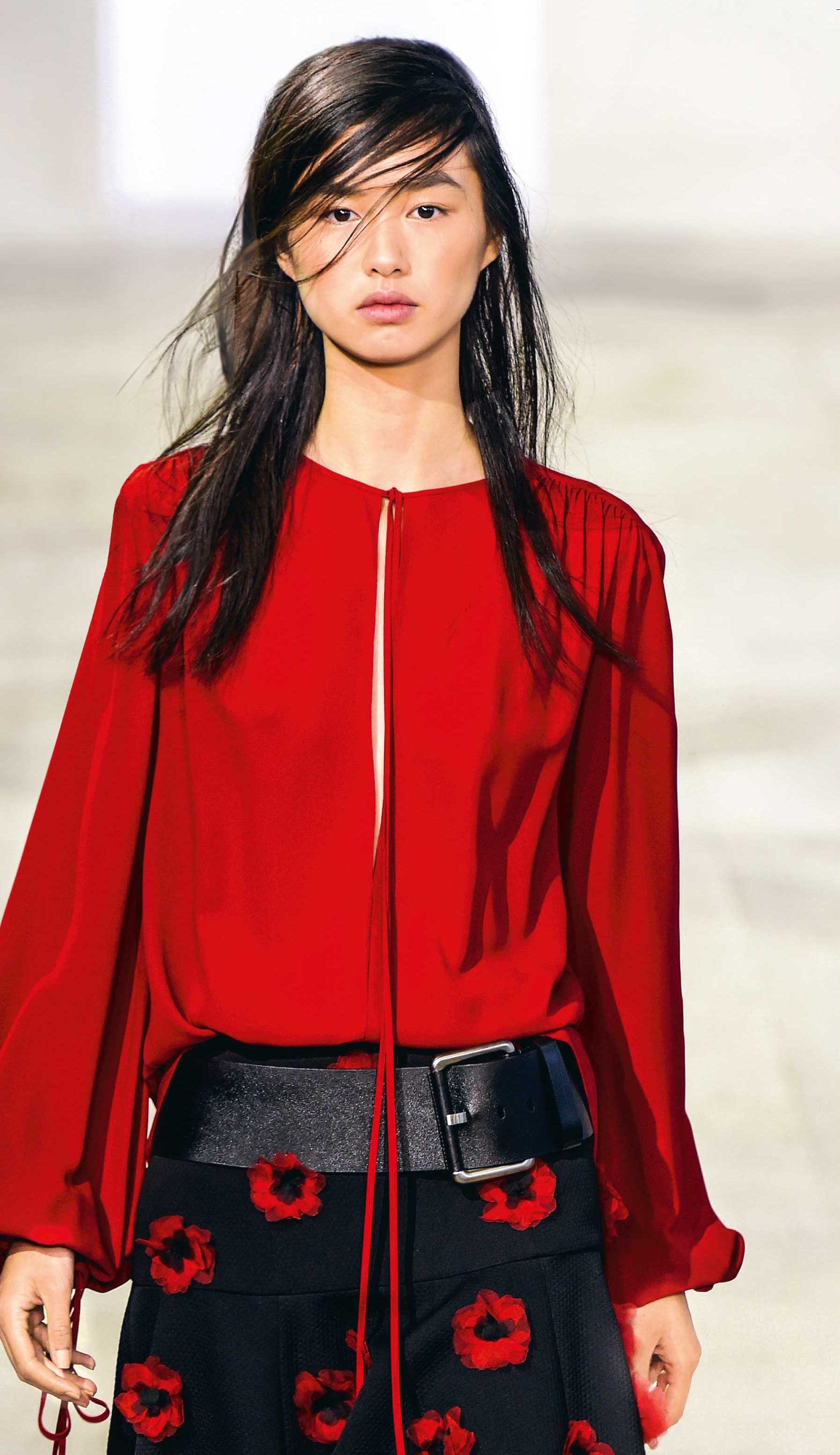 Modische rote Bluse, fließender Schnitt, dezente Falten. Schwarzer Rock, rote Blumenmuster, eleganter Look.