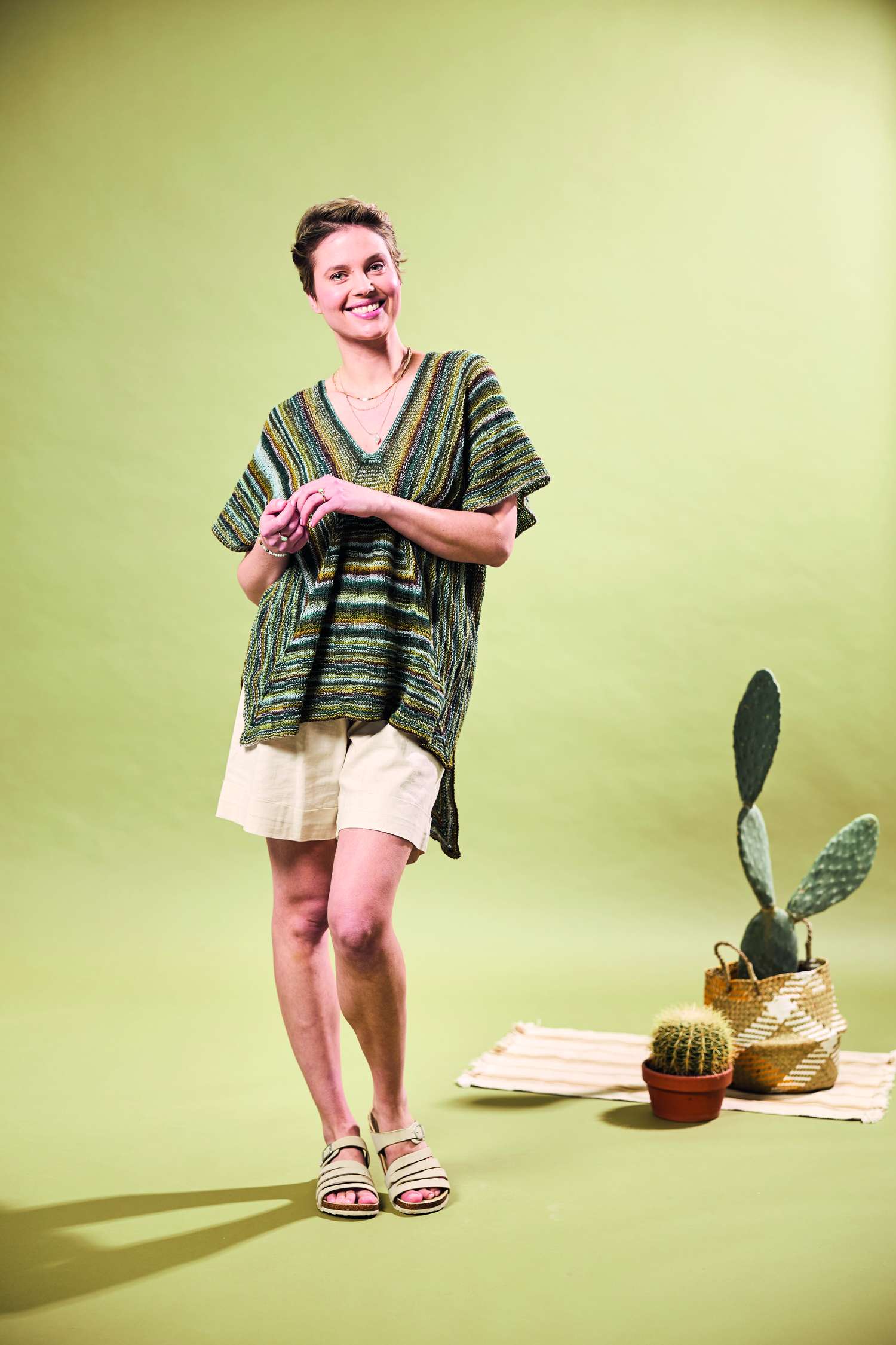 Selbstgemachter, gestreifter Pullover in Grüntönen mit lässigem Schnitt, kombiniert mit beigen Shorts. DIY-Vibes.