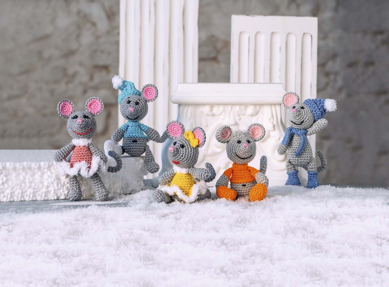 Graue Amigurumi-Mäuse in DIY-Kleidung: bunte Kleider, Mützen, Schals. Handarbeit mit kreativen Details.