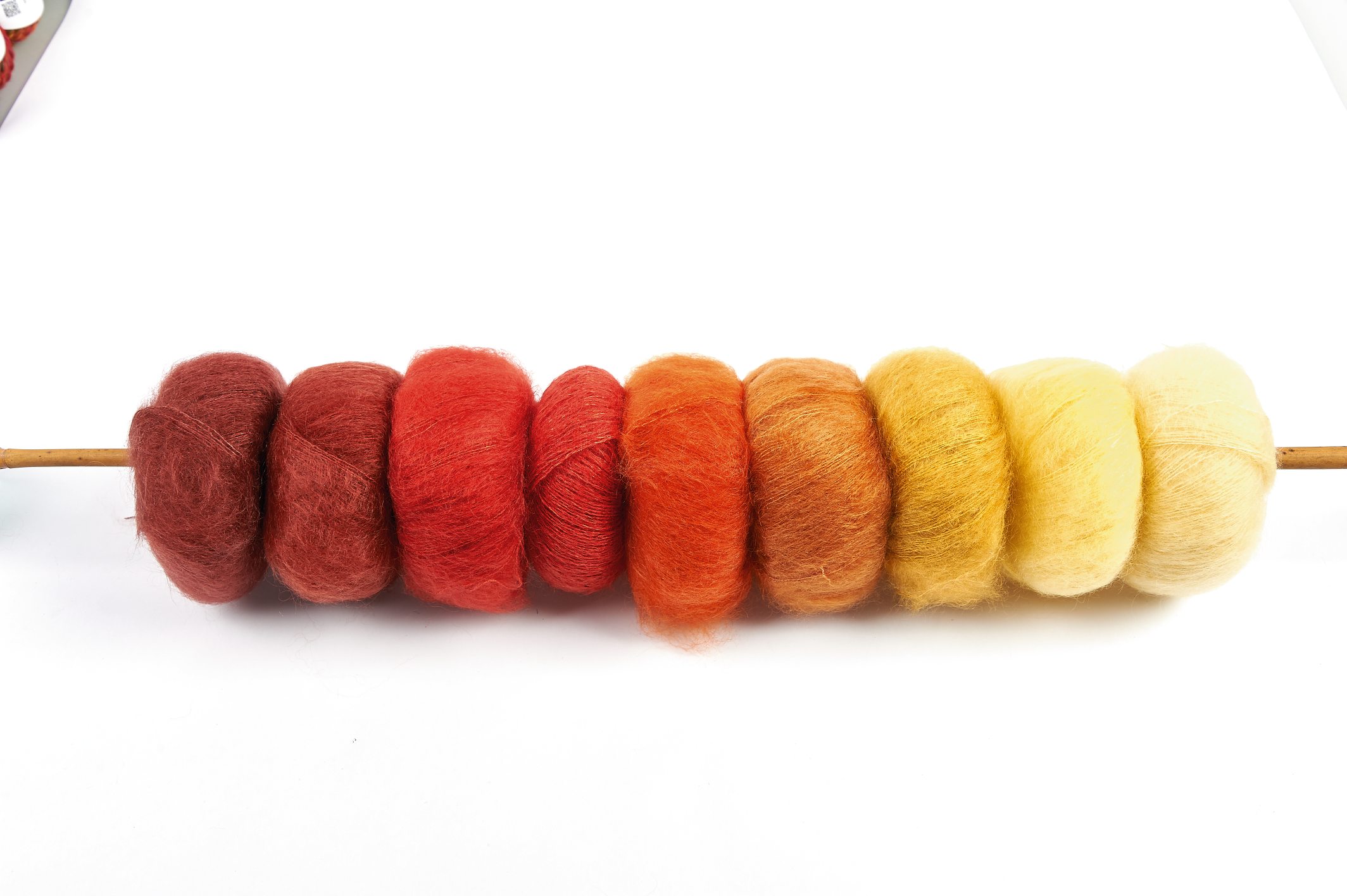 Wolle in warmen Tönen, von Rot zu Gelb. Perfekt fĂŒr DIY, handgemachte Projekte. Kuschelweiche Textur.