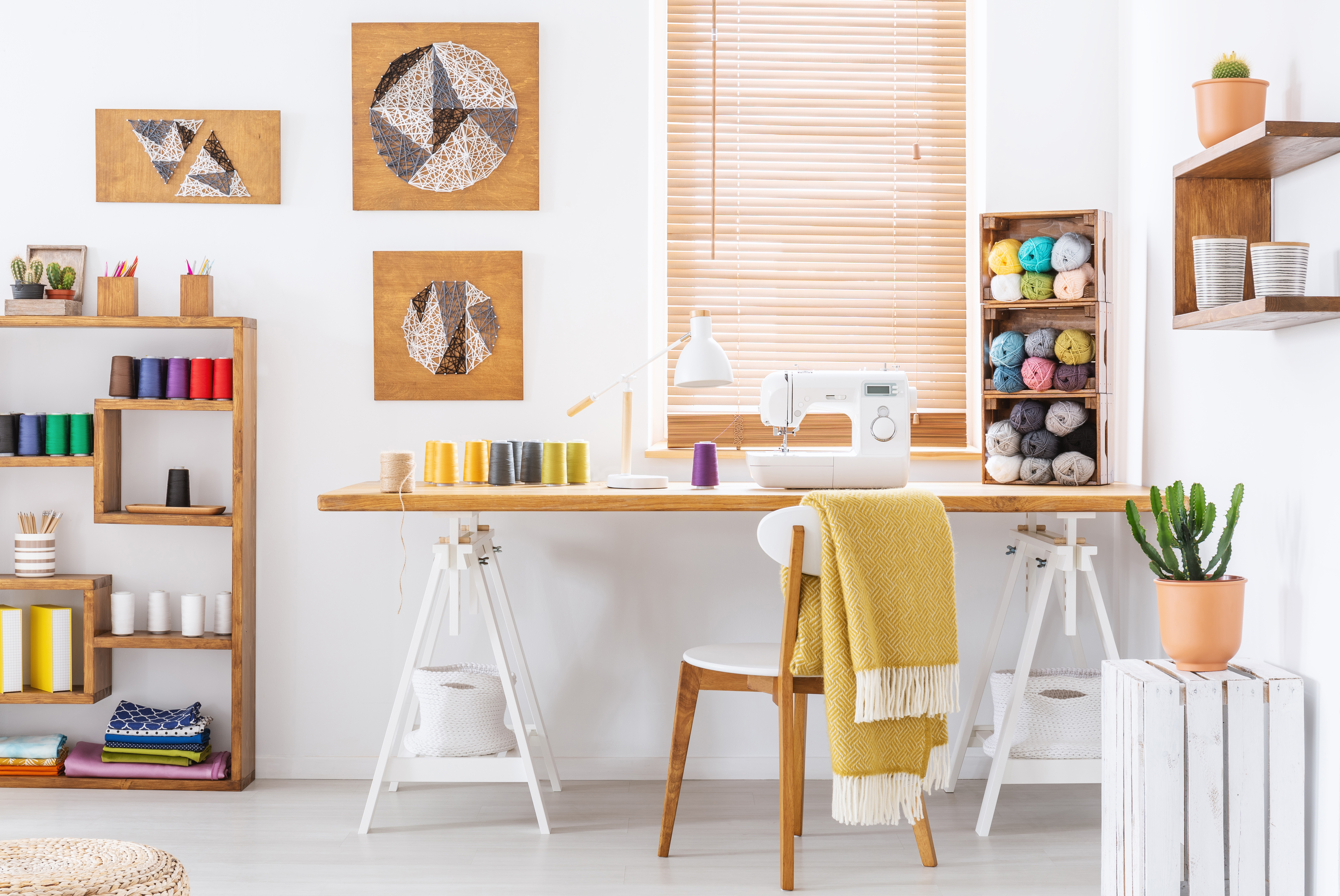 Warme Erdtöne, farbenfrohe Garnrollen, moderner DIY-Stil, kreative Muster, funktionales Nähzubehör.
