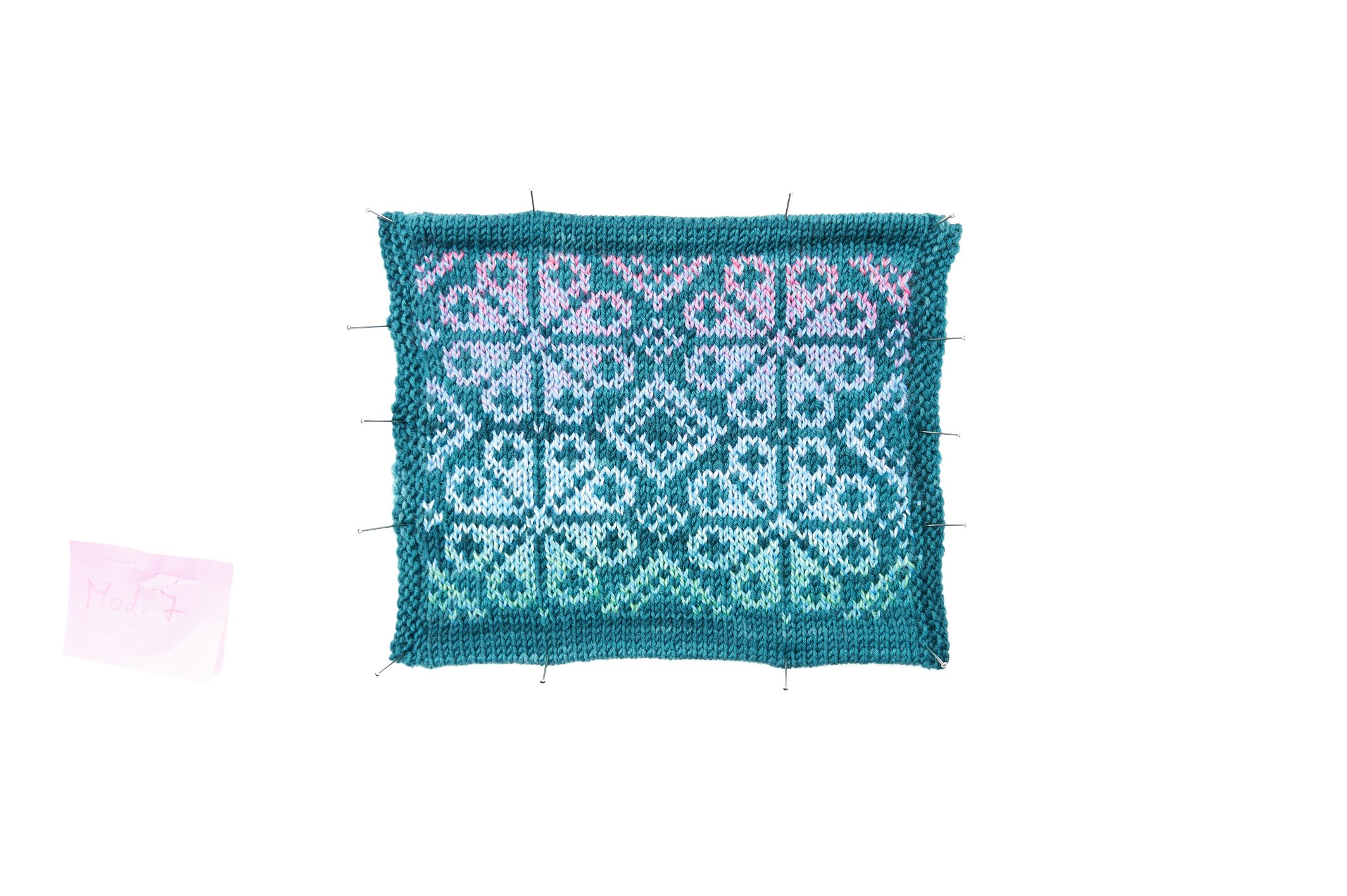 Selbstgemachtes Strickstück mit türkis-pinken Mustern, kunstvoll und modisch gestrickt.