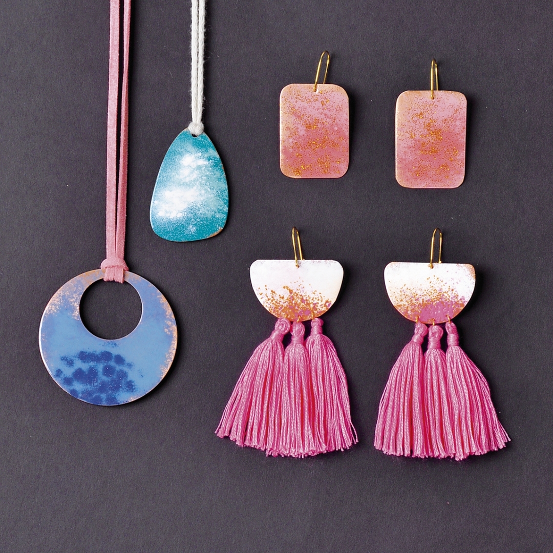 Bunter Schmuck mit rosa Quasten, blauen und goldenen Mustern. Modische, handgemachte Akzente.