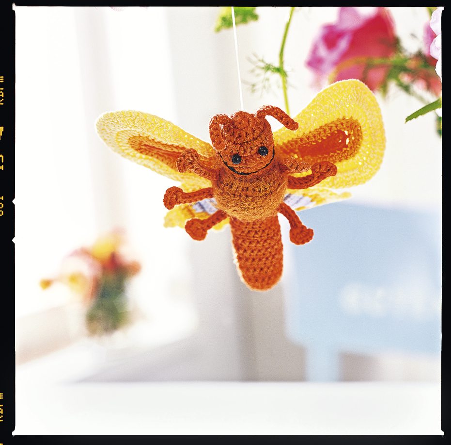 Handgemachter Schmetterling aus orange-gelben Garnen, detailgetreu gehäkelt, warmes Design. Modische Handarbeit.