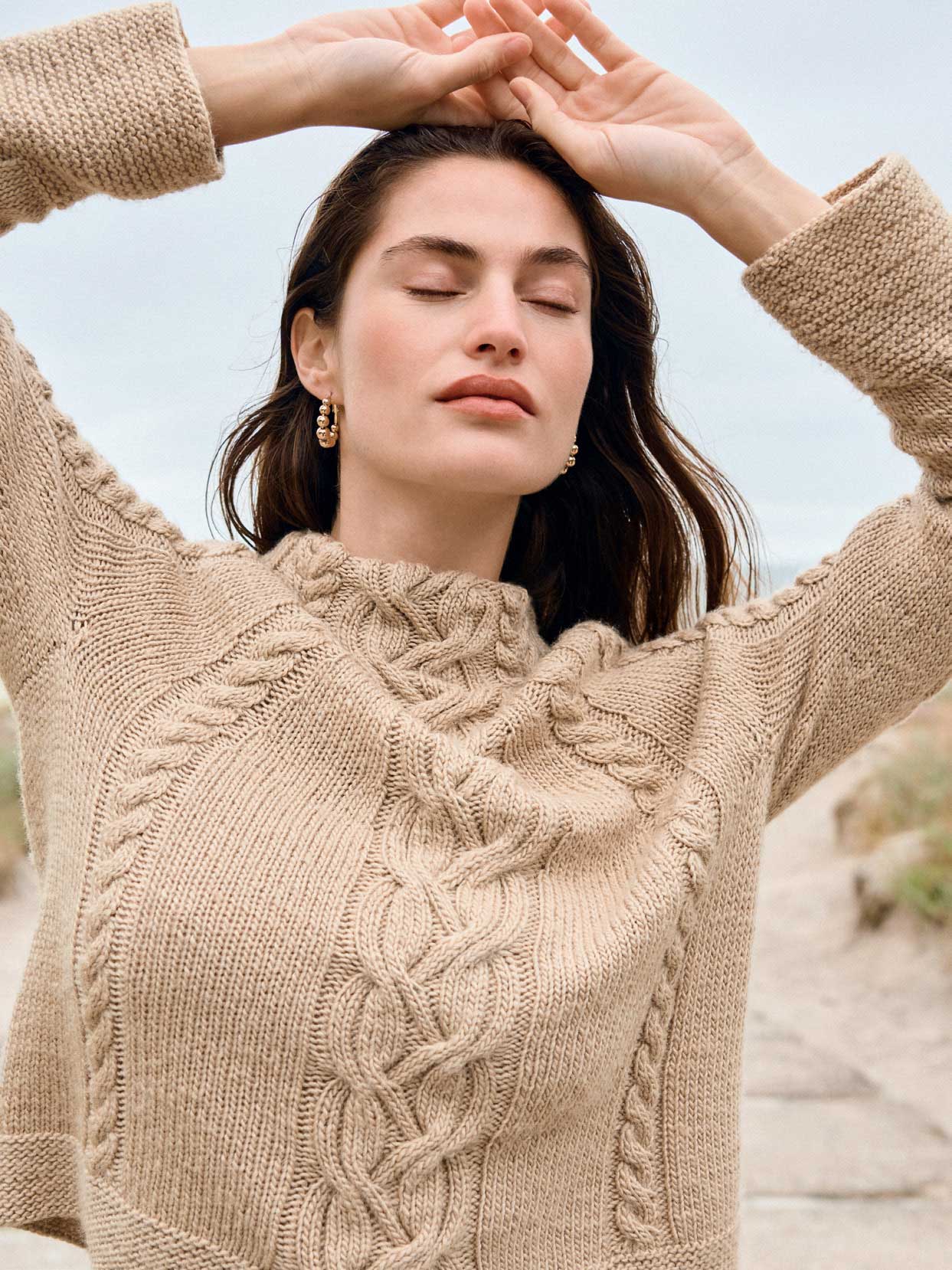 Beiger Pullover, aufwendig handgearbeitet, mit markantem Zopfmuster. Modisch, warme Strickstruktur.