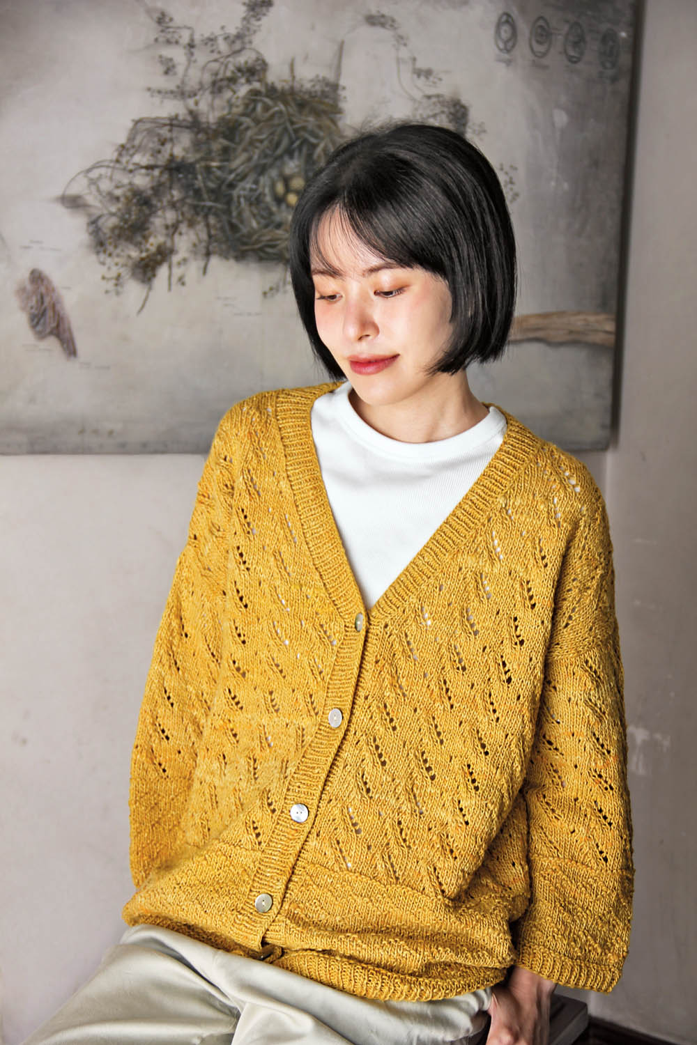 Handgestrickte, senfgelbe Strickjacke, Zopfmuster, lockerer Schnitt, modisch, DIY-Chic.