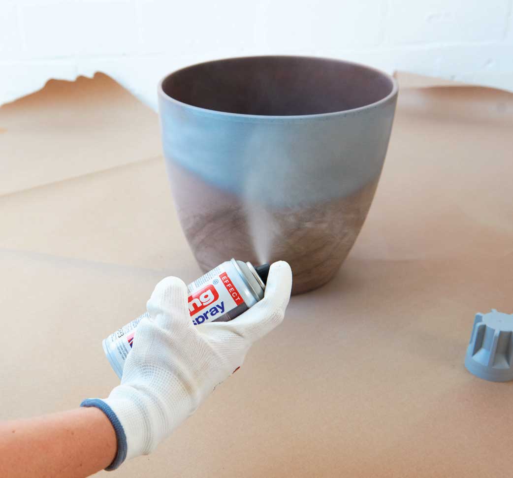 Sprühfarbe auf grauem Topf, sanfte Übergänge, handgemacht, kreative Akzente, glatte Oberfläche, modisch.