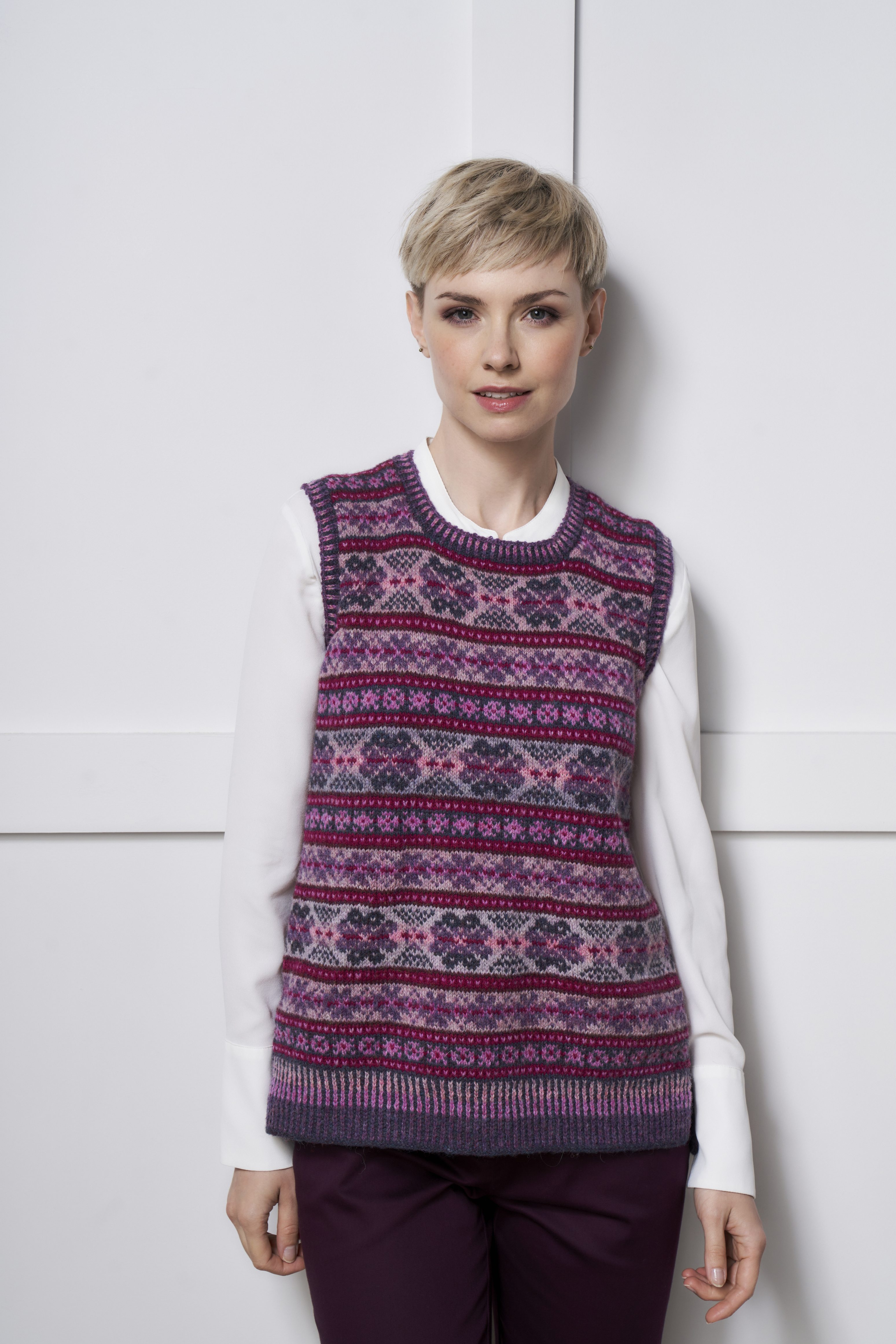 Pink-lila gemusterter Pullover, ärmellos, handgemacht, modisch, kontrastiert mit weißem Shirt. DIY-Schick.