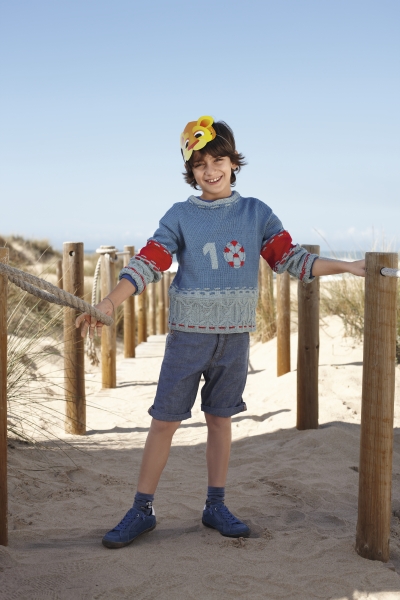 Modischer Strickpullover in Blau mit Zahlenmotiv und roten Akzenten. Schlichte Shorts, handgemacht, einzigartig.