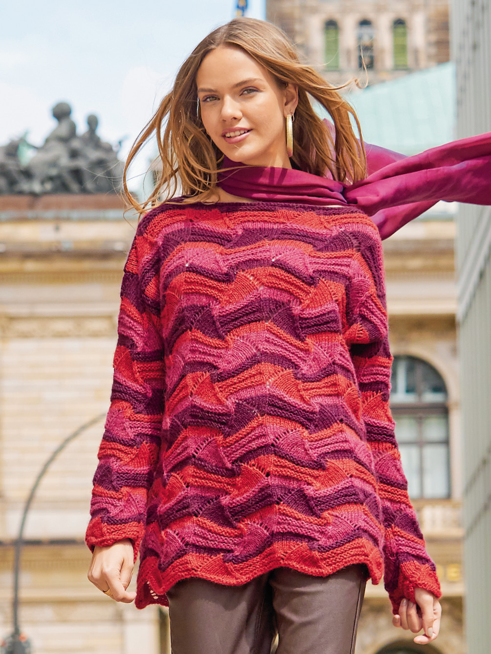 Modellansicht Bild 1: Pullover im Wellenmuster in Rot, Fuchsia und Aubergine