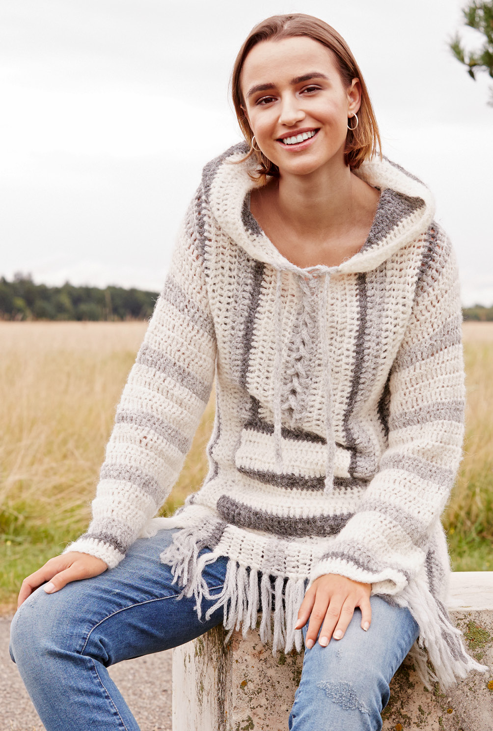 Handgemachter, gestreifter Pullover in Creme- und Grautönen mit Fransen; legerer Schnitt, modisches DIY-Stück.