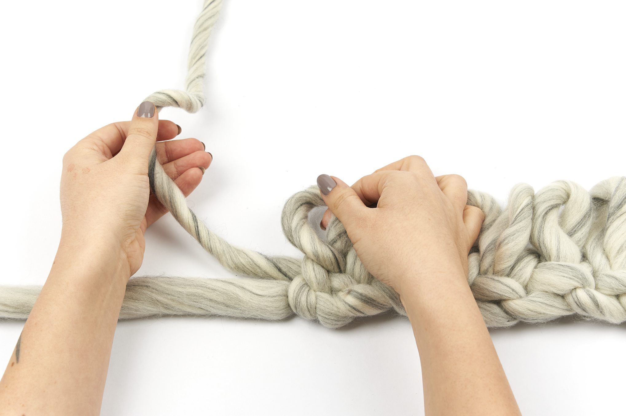 Grobe, beige-graue Wollstränge, handgefertigt. Einfache, modische Technik, ideal für selbstgemachte Handarbeiten.