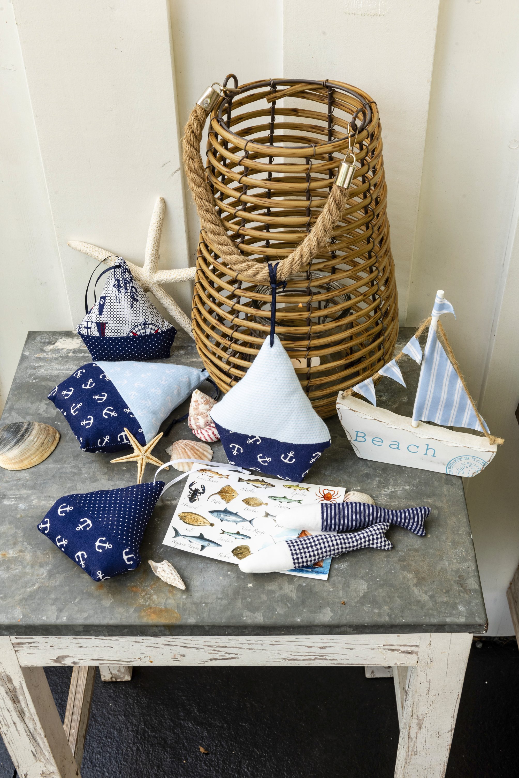Handgemachte, maritime Stoffkissen in Blau-Weiß mit Anker- und Streifenmustern. DIY Charme mit maritimen Details.