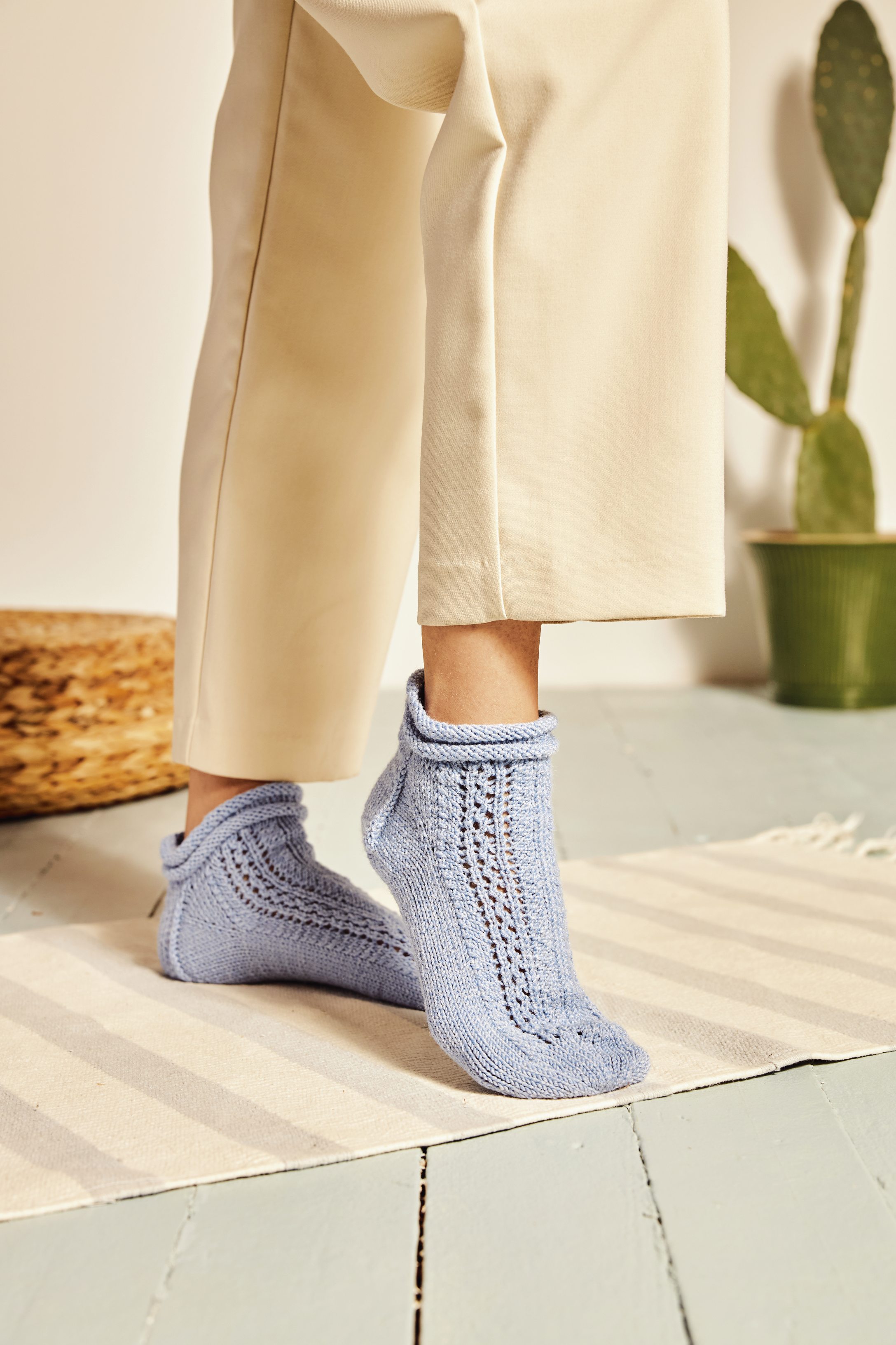 Hellblaue, gehäkelte Socken mit Lochmuster, modisch, selbstgemacht, detailreich, stilvoll.