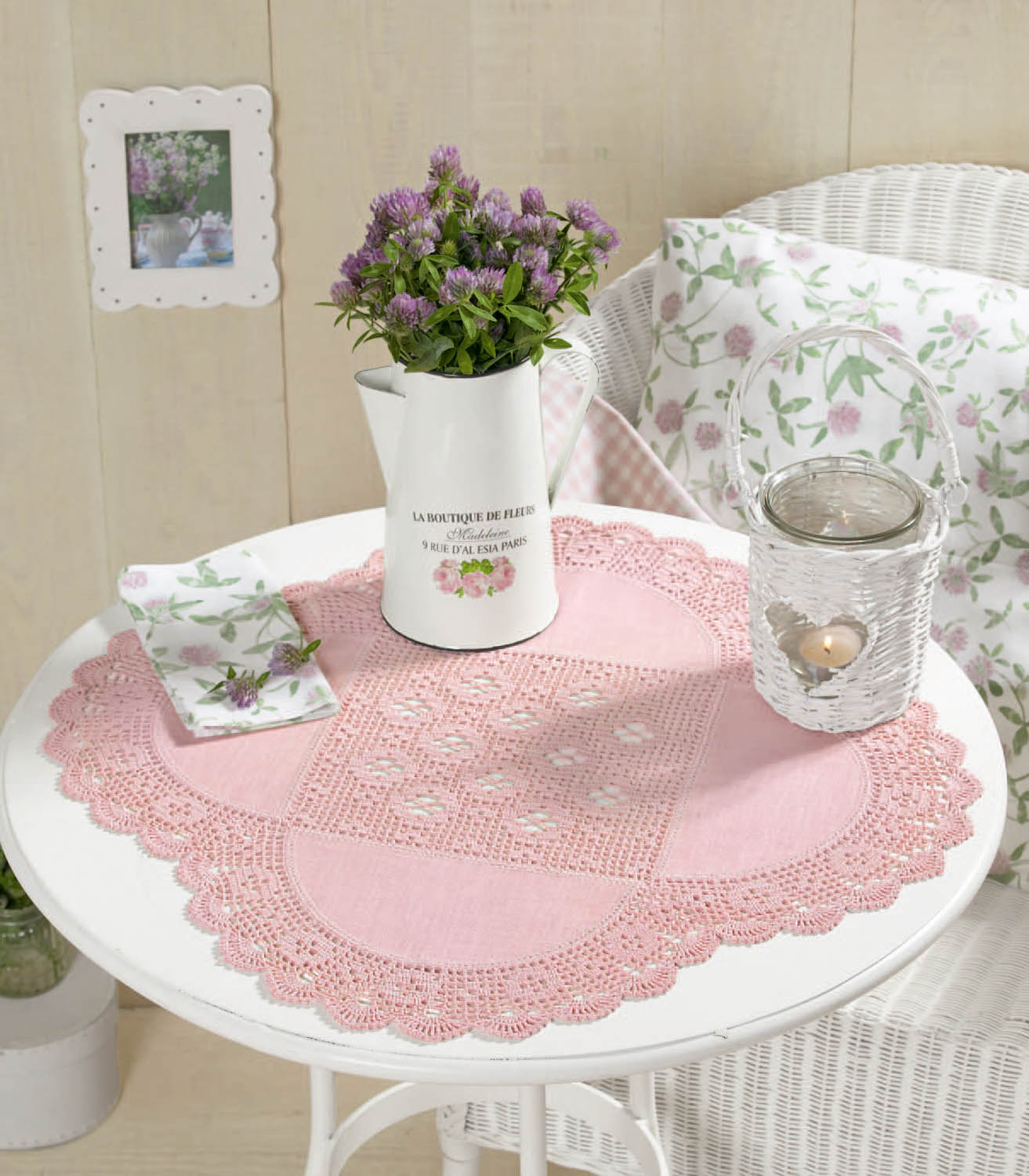 Rosa Häkeldeckchen, filigran, handgemacht, verziert einen runden Tisch, florale Muster für romantisches Flair.