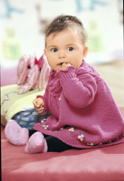 Pinkes, handgemachtes Strickkleid mit Blumenmuster, kombiniert mit farblich passenden Socken. Modisches Design.