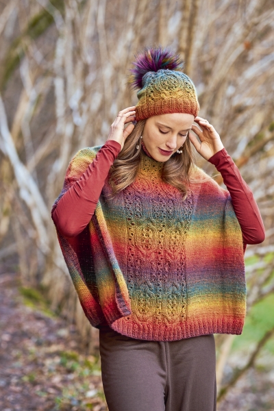 Poncho und Mütze in Regenbogenfarben, mit Zopfmuster. Handgemacht, modisch. Farbverlauf, warme Töne.