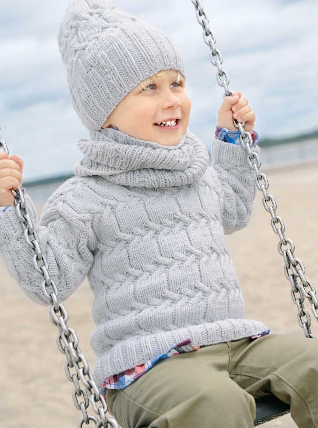 Handgemachter, grauer Strickpullover und Mütze. Modisches Zopfmuster, warm und bequem, ideal für kalte Tage.