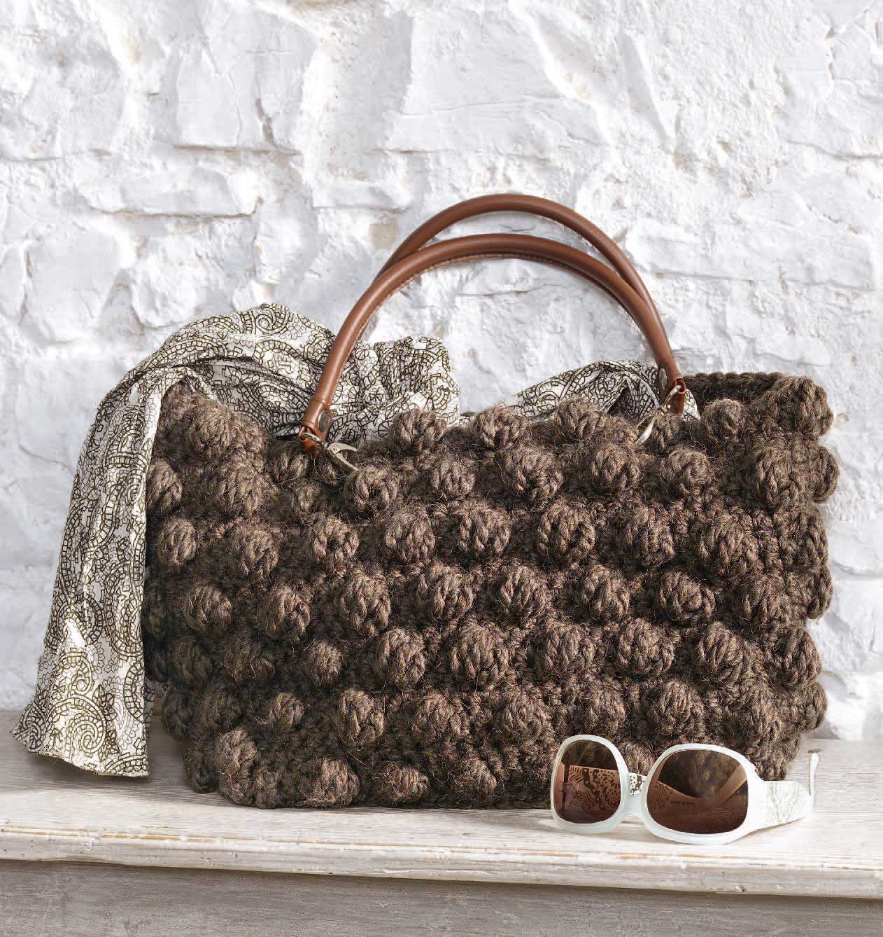 Große, braune, handgemachte Häkeltasche mit strukturiertem Muster und Ledergriffen, modisch und einzigartig.