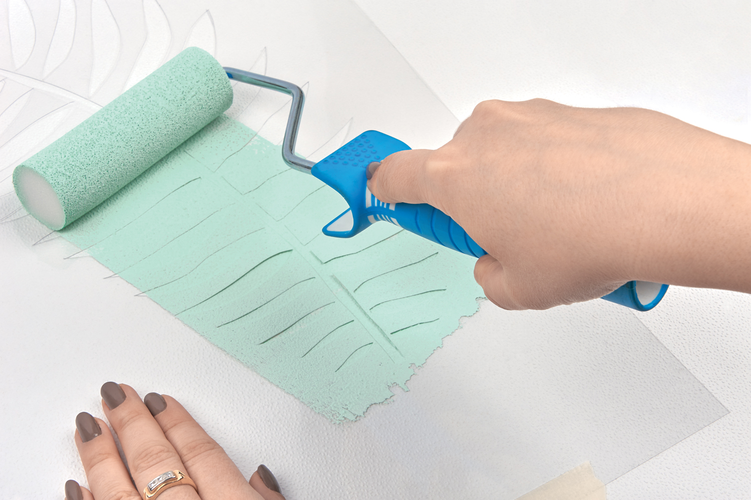 Selbstgemachtes Tapetenmuster, mintgrün; klare Linien; individuelle Handarbeit mit einem blauen Farbroller.