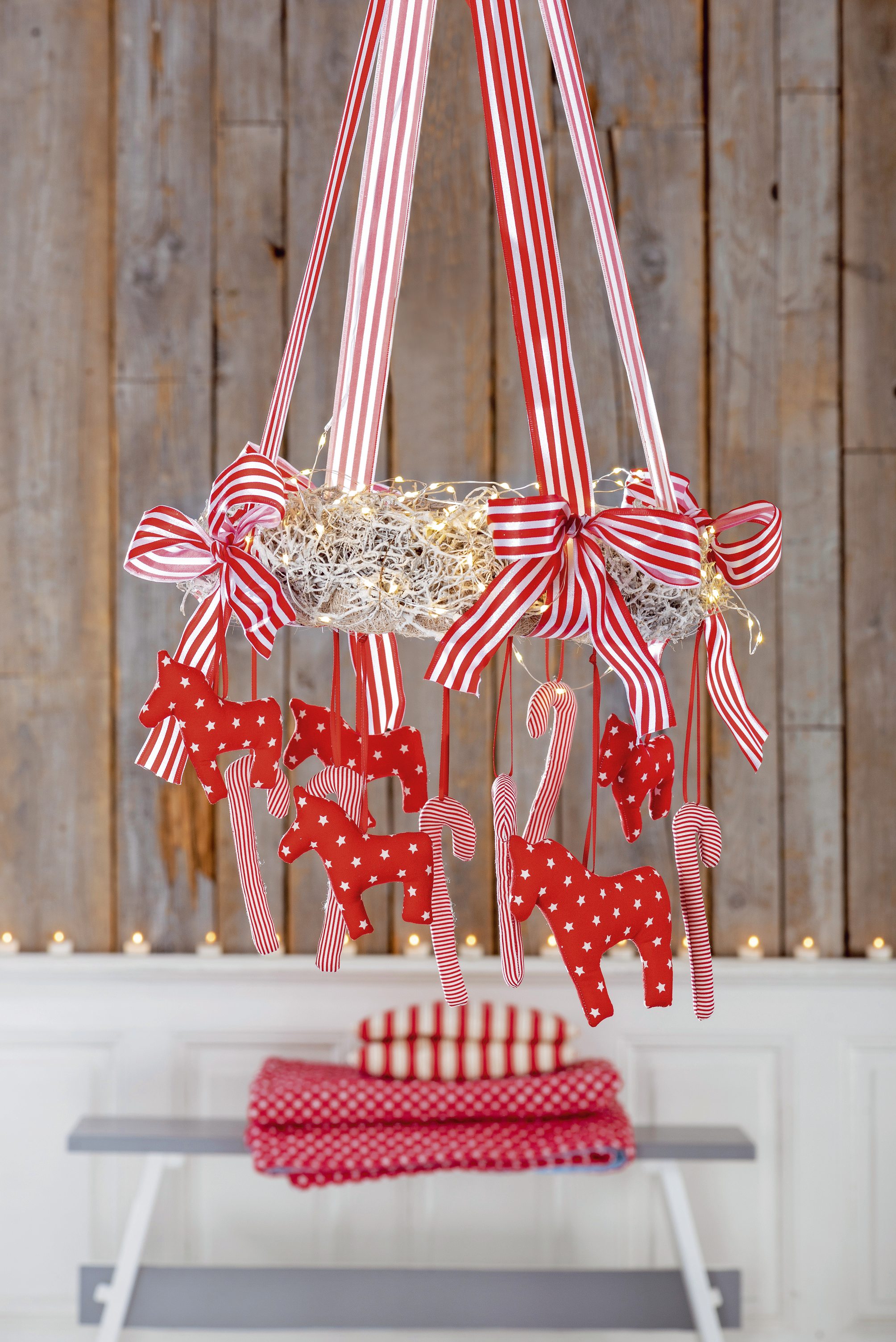 Rote, selbstgemachte Stofffiguren mit Streifen und Punkten hängen an gestreiften Bändern. DIY mit Liebe.