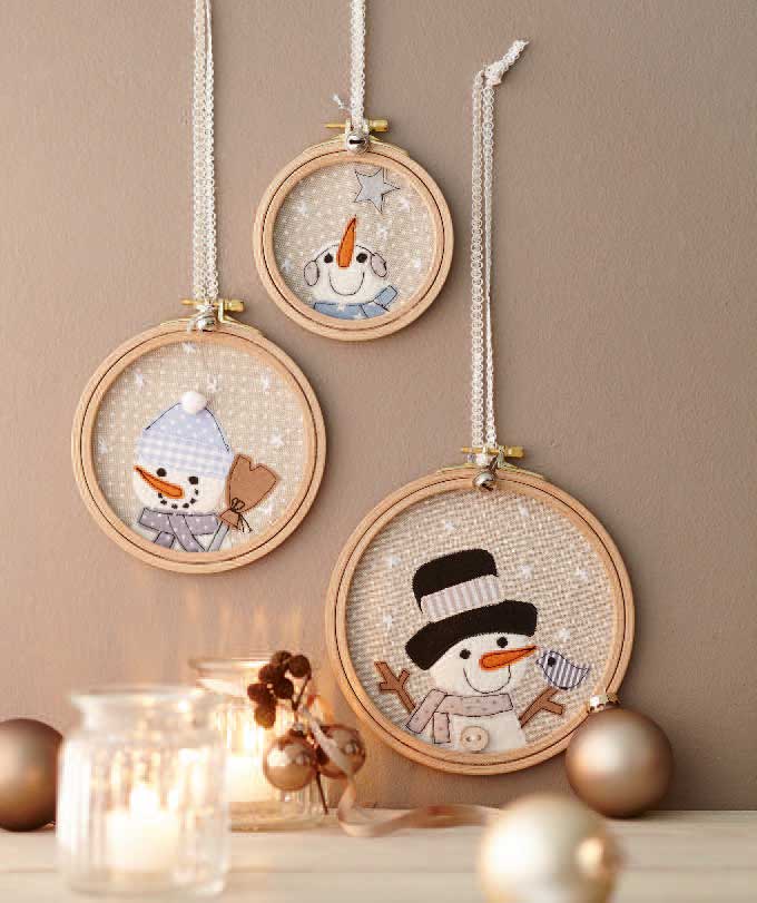 Kreative DIY Tischdeko: Drei Stickrahmen, Schneemannmotive im selbstgemachten Look, pastellfarbene Details.