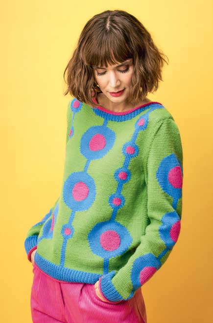 Grüner Pullover mit blauen und pinken Kreismustern, handgemacht, modisch, leuchtend.