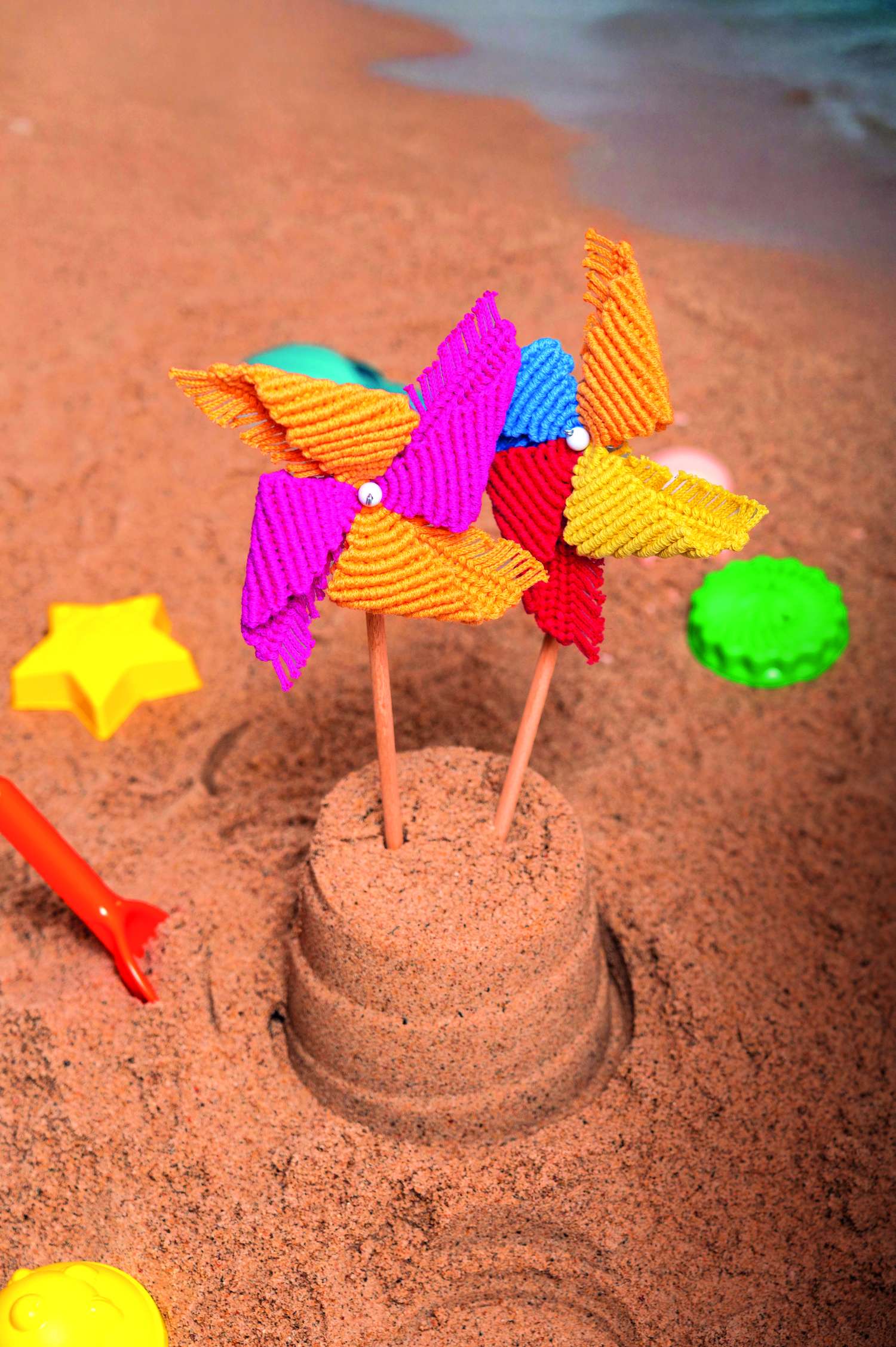 Leuchtende, handgemachte Windräder aus buntem, geripptem Stoff. Perfekt für einen modischen Akzent im Sand.