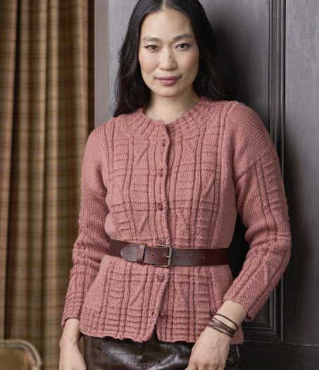 Modischer rosa Strickcardigan, geometrisches Muster, taillierter Schnitt, breiter Gürtel als Akzent.