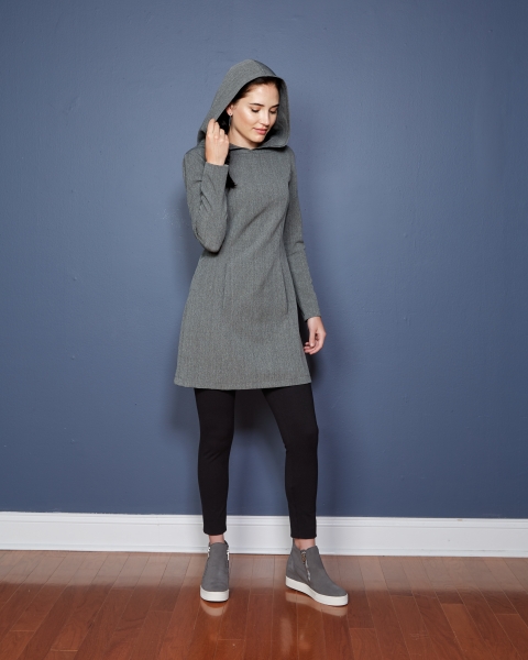 Graues Kleid mit Kapuze, schlichtes Design, kombiniert mit schwarzen Leggings. Modisch, minimalistisch.