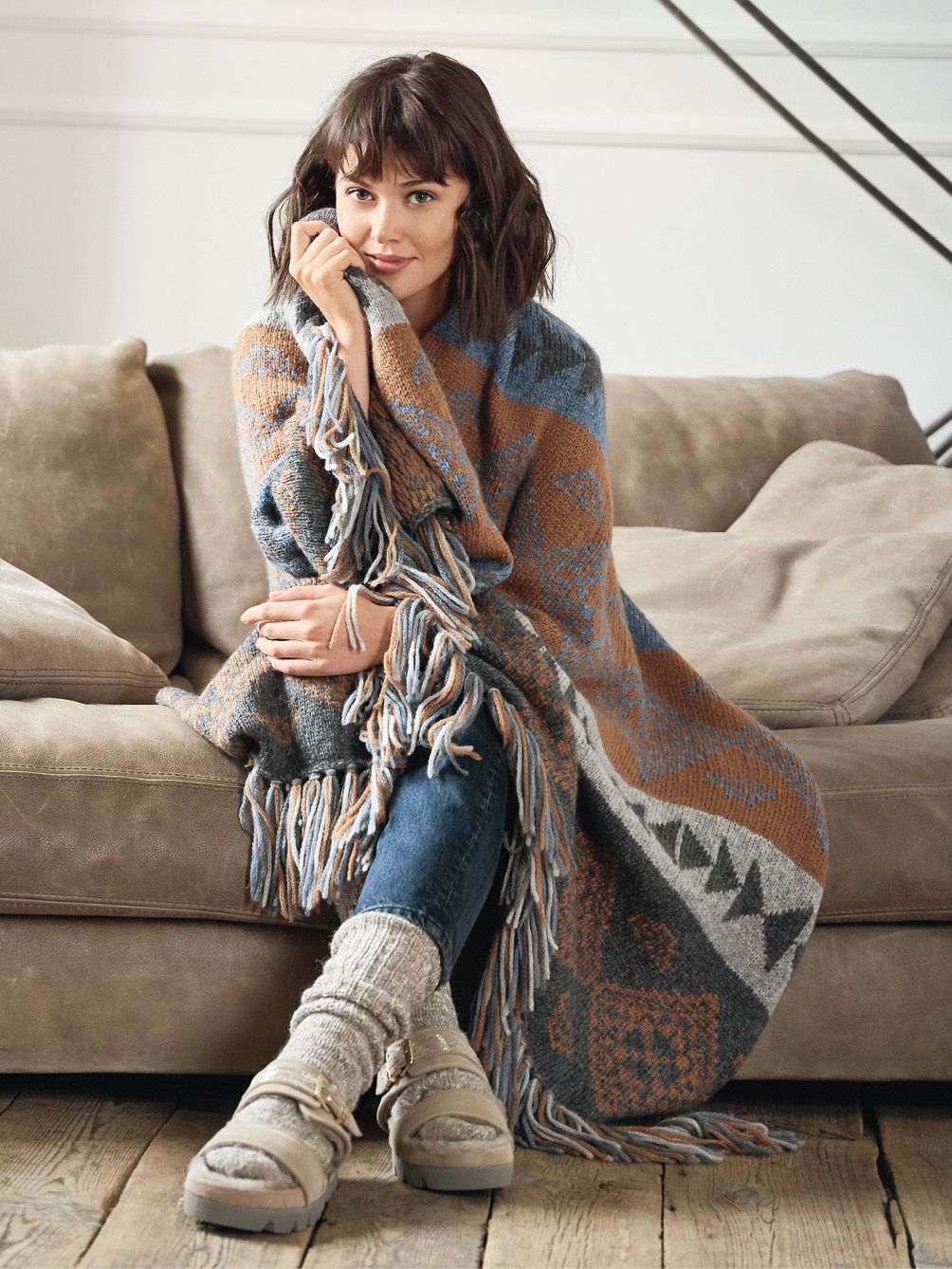 Poncho in Erdtönen mit Fransen, geometrische Muster. Modisch, DIY, handgearbeitet. Bequeme Jeans, warme Socken.