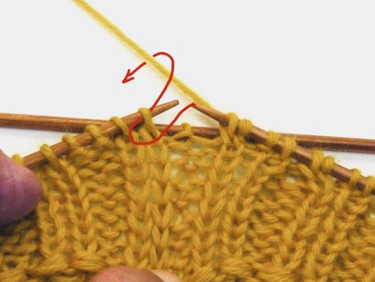 Gelbes, handgemachtes Strickstück mit detailreich symmetrischem Muster. DIY und kreativ.